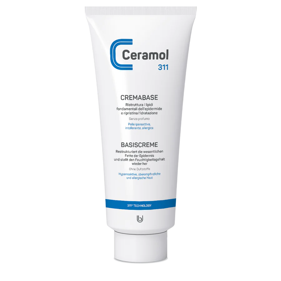 Eine weiße Tube CERAMOL BASISCREME 311 von Hinterland Apotheke mit blauem und schwarzem Text in Italienisch und Deutsch, einer blauen geschwungenen Linie, hebt die Vorteile für empfindliche Haut hervor und unterstützt die Hautbarriere und Lipidbarriere.
