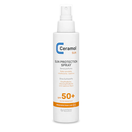 Eine weiße Sprühflasche mit SUN PROTECTION SPRAY SPF50+ für empfindliche Haut, mit orangefarbener und blauer Schrift, die als wasserfest und parfümfrei gekennzeichnet ist.