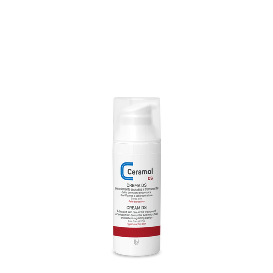 Ein weißer Flakon von Hinterland Apotheke CERAMOL CREME DS für Hautpflege und seborrhoische Dermatitis mit einem roten Streifen am Boden und einem blau-roten Logo steht auf einem schlichten schwarzen Hintergrund.