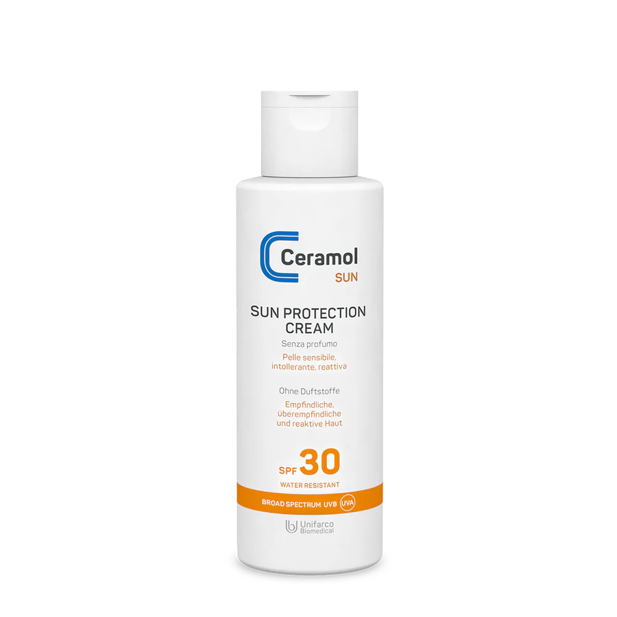 Weiße Flasche mit SUN PROTECTION CREAM SPF30 für empfindliche und reaktive Haut, mit orangefarbenen und blauen Akzenten und einem Flip-Top-Verschluss.