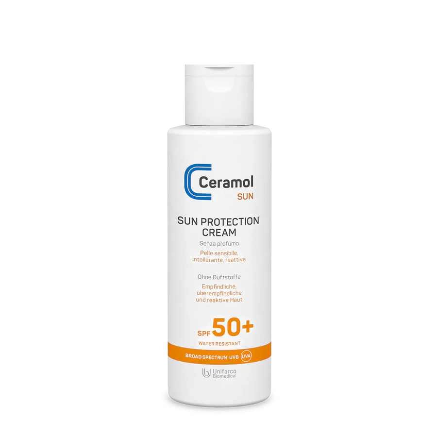 Eine weiße Flasche SUN PROTECTION CREAM SPF50+ mit orangefarbenem Etikett, ideal für empfindliche Haut. Sie ist wasserfest, bietet ein breites Spektrum an UVB/UVA-Schutz und zieht schnell ein.