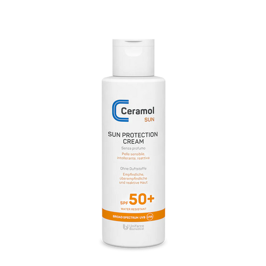 Eine weiße Flasche SUN PROTECTION CREAM SPF50+ mit orangefarbenem Etikett, ideal für empfindliche Haut. Sie ist wasserfest, bietet ein breites Spektrum an UVB/UVA-Schutz und zieht schnell ein.