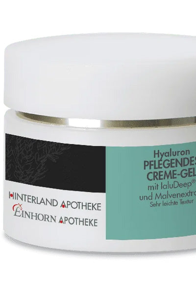 Nahaufnahme eines weißen Tiegels mit der Aufschrift Hyaluron Pflegendes Creme-Gel der Einhorn Apotheke, mit weißem Deckel und blau-grünem Etikett mit schwarzer und roter Schrift.
