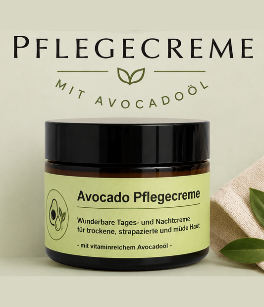 Ein Tiegel „Avocado-Pflegecreme“ mit grünem Etikett steht vor einem Schild mit der Aufschrift „Pflegecreme mit Avocadoöl“. Grüne Blätter neben dem Tiegel unterstreichen die natürlichen Hautpflegelawerte und das reichhaltige Avocadoöl, das in dieser nährstoffreichen Avocado-Pflegecreme enthalten ist.