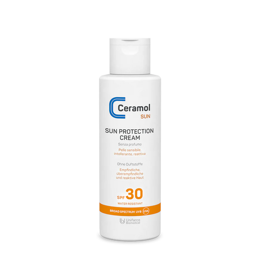 Weiße Flasche mit SUN PROTECTION CREAM SPF30 für empfindliche und reaktive Haut, mit orangefarbenen und blauen Akzenten und einem Flip-Top-Verschluss.
