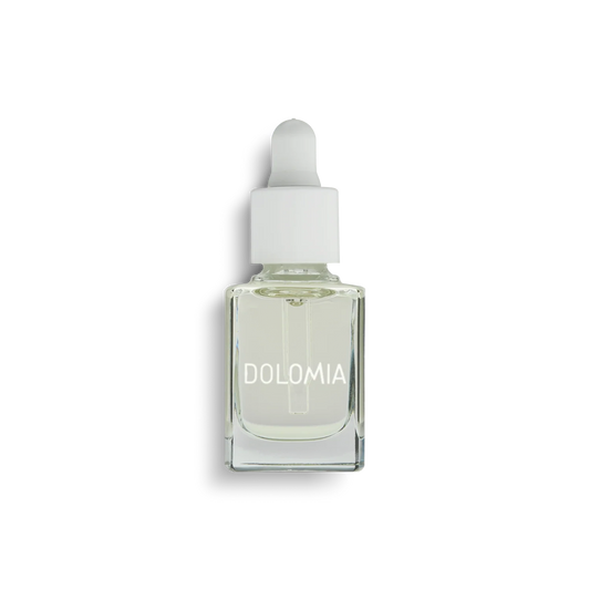 Tropfflasche aus Klarglas mit weißem Verschluss, gefüllt mit hellgelbem Natürlichem Pflegeöl. Auf dem Etikett steht DOLOMIA in Weiß. Das Produkt ist ideal für die Pflege der Nagelhaut und steht auf einem schlichten weißen Hintergrund.
