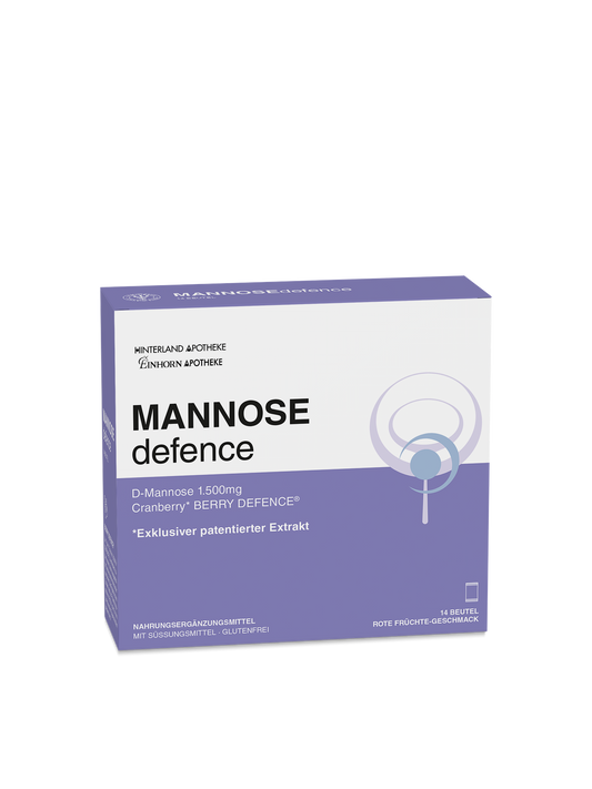Eine weiß-lila Schachtel mit der Aufschrift MANNOSEdefence (deutsche Angaben), die 16 Beutel Cranberry-Defense-Ergänzungsmittel mit 1500 mg D-Mannose plus Vitamin C enthält und als glutenfrei und zuckerfrei beschrieben wird.